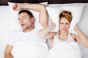 Man Snoring with Wife Covering Ears